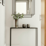 L&rsquo;ingresso &egrave; uno degli spazi pi&ugrave; importanti della casa, anche se spesso viene trascurato. &Egrave; il primo ambiente che accoglie chi entra e, allo stesso tempo, il punto di passaggio che collega l&rsquo;esterno con la zona giorno. Proprio per questo dovrebbe essere funzionale, ordinato e coerente con lo stile dell&rsquo;abitazione. Tuttavia, non sempre si dispone di metrature generose: in molti casi si tratta di spazi stretti, corridoi o piccoli angoli da valorizzare con soluzioni intelligenti. Progettare un ingresso moderno significa trovare il giusto equilibrio tra estetica e praticit&agrave;. Anche pochi elementi ben scelti possono fare la differenza e trasformare completamente la percezione dell&rsquo;ambiente. Uno degli arredi pi&ugrave; utilizzati &egrave; la consolle salvaspazio, ideale per appoggiare chiavi, posta o piccoli oggetti quotidiani. Le versioni pi&ugrave; moderne sono leggere, sospese o dal design minimale, perfette per non appesantire visivamente lo spazio. In alternativa, si possono scegliere mensole sottili che svolgono la stessa funzione ma occupano ancora meno spazio. Un altro elemento fondamentale &egrave; lo specchio, che non solo ha una funzione pratica, ma contribuisce anche ad ampliare visivamente l&rsquo;ambiente. Uno specchio grande o dalla forma particolare pu&ograve; diventare il vero punto focale dell&rsquo;ingresso, riflettendo la luce e rendendo lo spazio pi&ugrave; arioso e luminoso. L&rsquo;illuminazione gioca un ruolo essenziale nella progettazione di un ingresso accogliente. Spesso si tratta di ambienti privi di luce naturale, quindi &egrave; importante studiare punti luce ben distribuiti. Applique moderne, lampade a sospensione o strisce LED integrate possono creare un&rsquo;atmosfera calda e contemporanea, valorizzando al tempo stesso gli arredi. Per mantenere l&rsquo;ordine &egrave; utile inserire contenitori e soluzioni contenitive intelligenti, come mobili con vani chiusi, panche con spazio interno o appendiabiti da parete. Questi elementi permettono di organizzare scarpe, giacche e accessori senza creare disordine visivo, mantenendo l&rsquo;ingresso sempre in ordine. Infine, anche la scelta dei materiali e dei colori contribuisce a definire lo stile dell&rsquo;ambiente. Toni neutri, superfici leggere e materiali naturali aiutano a creare un ingresso armonioso e moderno, mentre piccoli dettagli decorativi possono aggiungere personalit&agrave; senza appesantire lo spazio. Arredare bene l&rsquo;ingresso significa quindi sfruttare ogni centimetro con soluzioni pratiche ma curate nel design. Un ambiente ben progettato non solo migliora la funzionalit&agrave; della casa, ma trasmette subito una sensazione di ordine e accoglienza fin dal primo passo.
